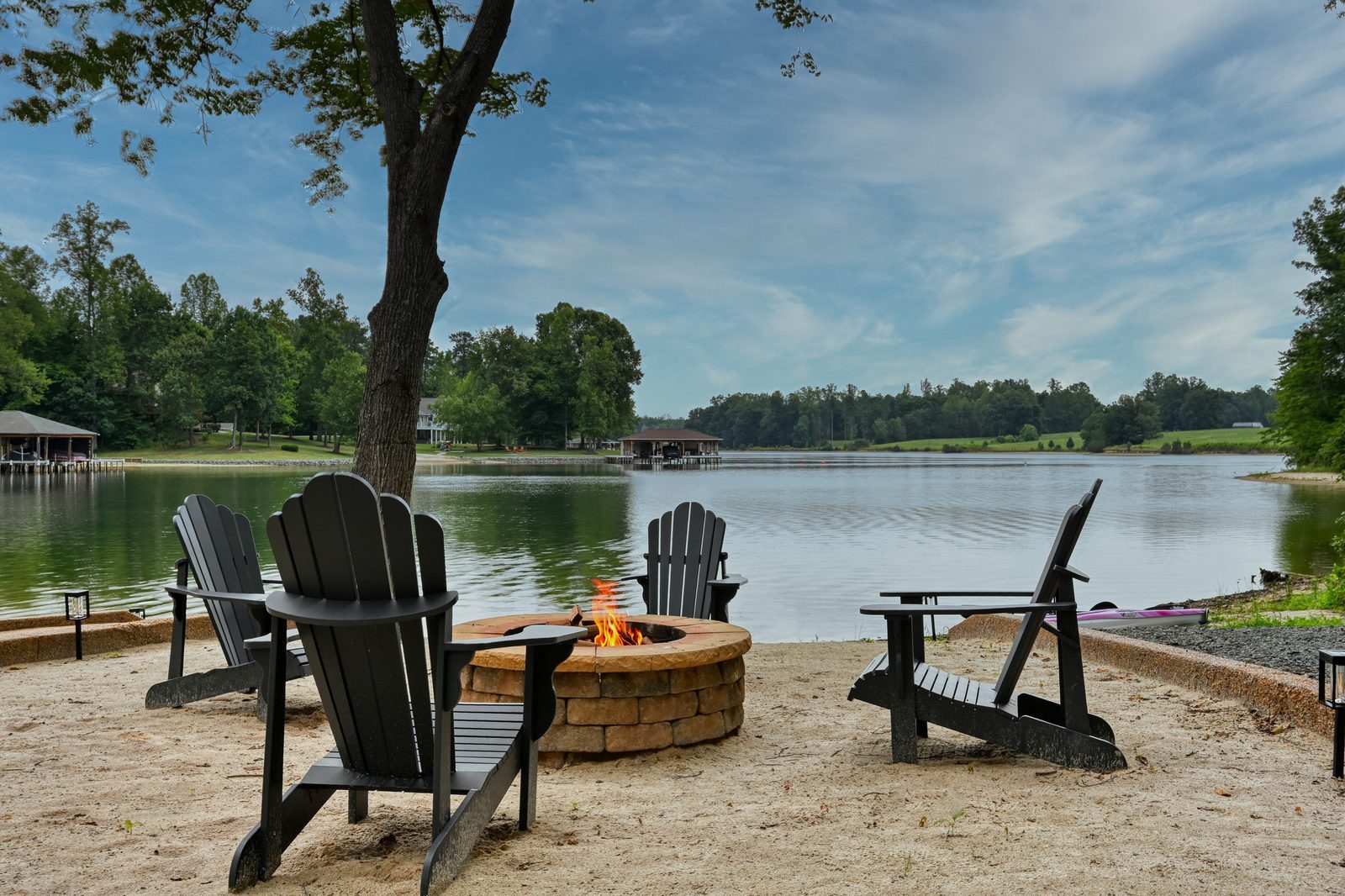 Adirondack chairs around a fire pit on the beach