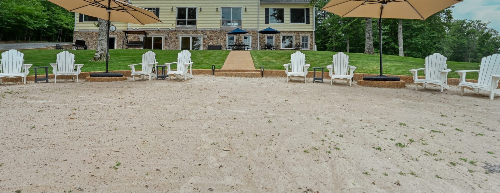 Wide stretch of soft sand beach lined with Adirondack chairs and umbrellas