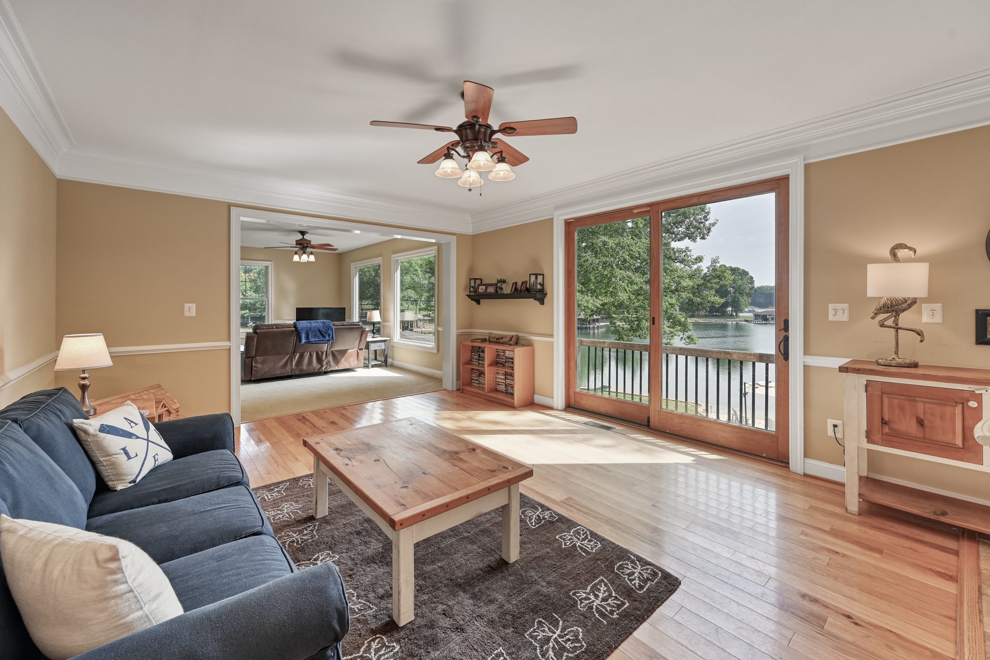 Sunny living room with navy sofas and sliding doors to the lake